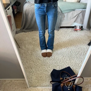 Lågmidjade bootcut jeans - Lågmidjade bootcutjeans från Gina Tricot Young. Storlek 164, är 170 och de passar mig, jag bär annars storlek 34/36. Stretchiga, blåa jeans.