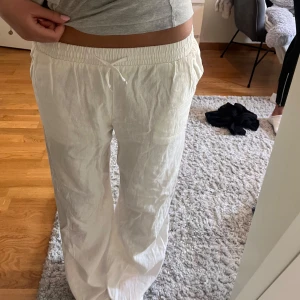 Vita linnebyxor med snörning - Säljer ett par vita linnebyxor med elastisk midja och snörning framtill. Storleken är 158 men jag är 160 cm lång och tyvärr är de lite långa för mig. 