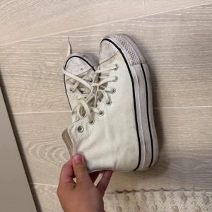 Vita Converse Chuck Taylor high tops - Säljer ett par klassiska vita Converse Chuck Taylor All Star high tops med svart rand längs sulan och rund tå. Tvättar såklart i tvättmaskin om det önskas innan jag postar dem! 🧸