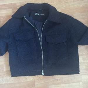 Svart teddyjacka från Zara - Säljer en mörkblå teddyjacka från Zara i mjukt ullaktigt tyg och två stora fickor framtill. Jackan har en jättesnygg krage! Säljer den pågrund av att den aldrig kommit till andvändning för mig, så den är helt oanvänd!🙌❤️