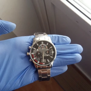 Stilren silverfärgad kronografklocka - Säljer en snygg kronografklocka från Q&Q med svart urtavla och detaljer i rött och vitt. Klockan har flera små urtavlor, markerade index och en robust länk i blankt silverfärgat metall. Perfekt för dig som gillar sportig och modern stil.