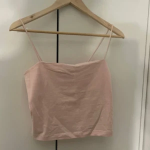Ljusrosa linnetopp från Gina Tricot - Supersöt ljusrosa linnetopp från Gina Tricot med smala axelband och rak, croppad passform. 