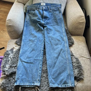 Wrangler Redding loose straight jeans - Blå jeans från Wrangler, modell Redding loose straight. Klassisk femficksdesign med raka och lösa ben, midwaist och ljusblå tvätt. Snyggt läderpatch bak på linningen. Perfekta för dig som gillar avslappnad stil och bredare passform.