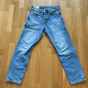Blå relaxed jeans från H&M, 29/32 - Säljer ett par blå relaxed fit jeans från H&M i storlek 29/32. Jeansen har klassisk femficksdesign, raka ben och knappgylf. Materialet är jeans med ljusblå tvätt och kontrastsömmar. Perfekt för dig som gillar en loose och chill stil.