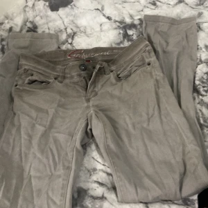 Mörk beige låg midja slim jeans från Esprit - Snygga  jeans från Esprit i modellen FIVE slim. De har klassisk femficksdesign, broderad detalj på bakfickan och smal passform. Materialet är mjukt och stretchigt för extra komfort. Perfekt för dig som gillar stilrena och enkla jeans. Passar dig bäst om du är 155cm