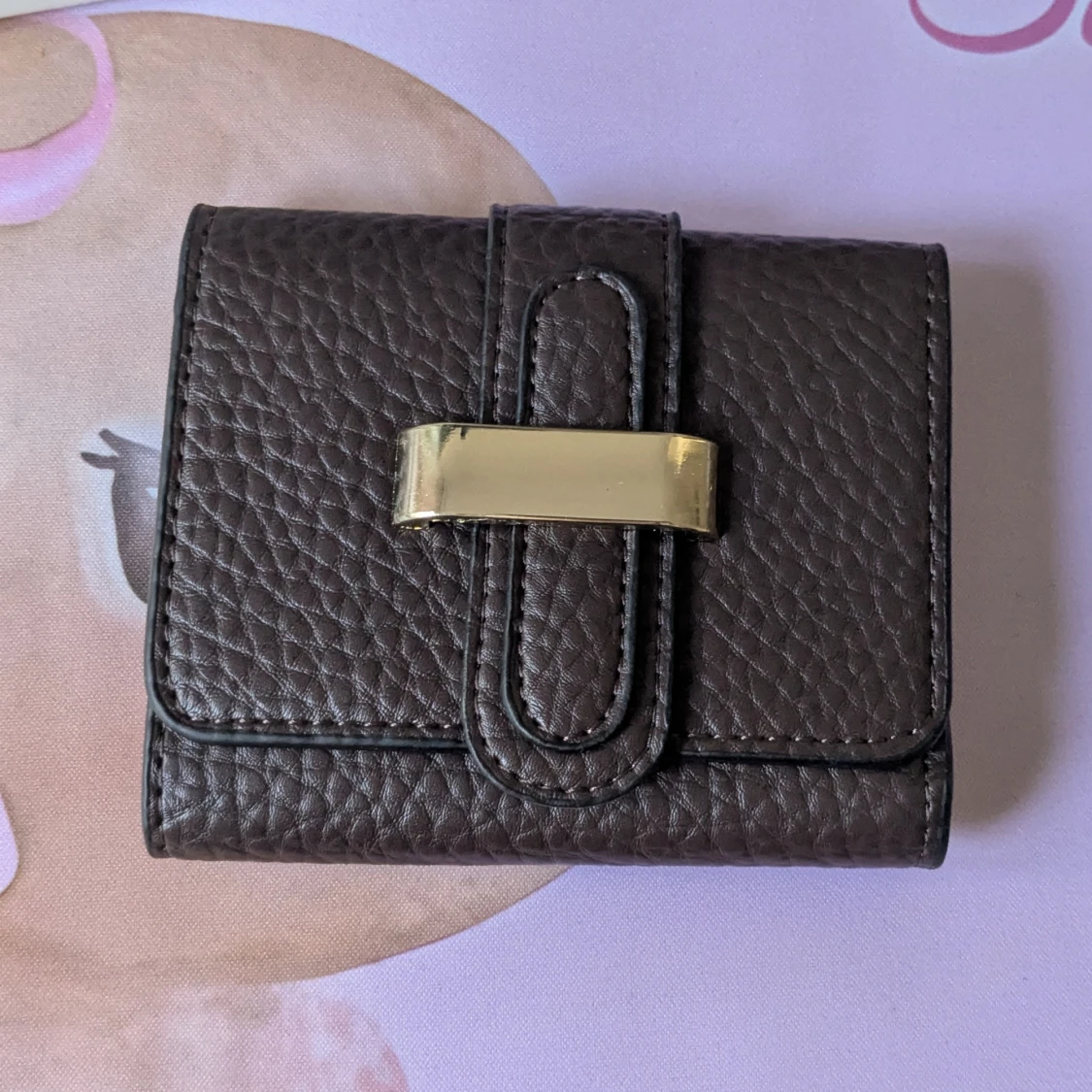 Mörkbrun plånbok med guldfärgad detalj