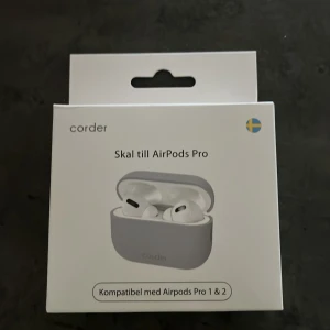Grått AirPods Pro skal från Corder - Skyddande och stilrent grått skal till AirPods Pro från Corder. Passar både Gen 1 och 2 och är kompatibelt med Qi-laddare. Skalet är tillverkat i slitstark syntet och håller laddfodralet fritt från repor och märken. Perfekt för dig som vill ha ett cleant och enkelt skal.
