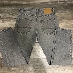 Grå relaxed jeans från Jack & Jones - Säljer ett par Snygga gråa jeans från Jack & Jones i modell Relaxed/Chris i storlek W27 L30. Pris kan diskuteras vid snabb affär.