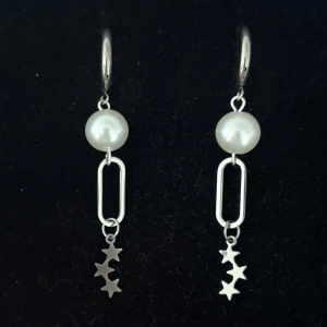 Silvriga örhängen med pärlor och stjärnor - Handgjorda och unika silverörhängen 🤩 Öronhängerna är nickelfria och silverpläterade i kirurgiskt stål, resterande av örhänget är i rostfritt stål (ej silverpläterat) 💕🙏 4.5 cm långa. Alla köp görs via ”KÖP NU” knappen.  💐