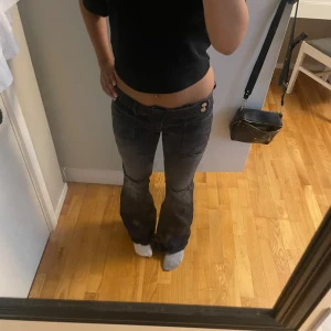 Svarta bootcut jeans från Gina Tricot - Säljer ett par svarta jeans från Gina Tricot i storlek 170. Modellen har låg midja, bootcut-ben och coola slitningar vid knäna. Jeansen har framfickor med sömdetaljer. Säljer då de är för stora för mig. Helt nya, utom att jag tvättat dom och hålen har blivit lite större. Långa på mig som är 170 ❤️