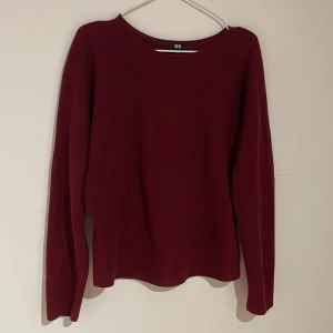 Vinröd bomullströja från Uniqlo - Snygg vinröd långärmad tröja från Uniqlo i storlek L. Tröjan är tillverkad i 100% bomull och har en enkel, clean design med rund hals. Perfekt för dig som gillar stilrena plagg med skön passform och mjukt material.