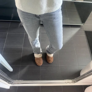 Grå jeans från Gina tricot - Snygga grå jeans från Gina, storlek 34. Färgen är lite urtvättad och de är lite slitna längst nere vid fötterna men inga desvärre defekter. Använd gärna ”KÖP NU” nypriset ligger på 500kr