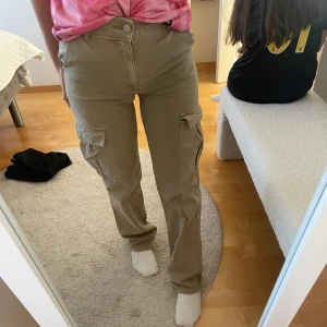 Beige cargopants med hög midja - Kommit till användning ett fåtal gånger, köpta ifrån pull & Bear i storlek 32