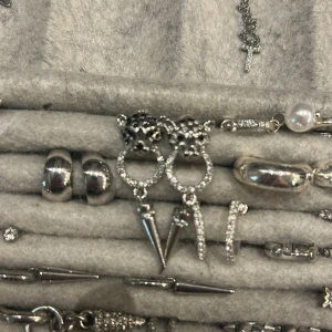 Silverfärgade örhängen med leopardhuvud och strass - Coola silverfärgade örhängen med leopardhuvud upptill, cirkel dekorerad med glittrande stenar och en spetsig hängande detalj. Ger en edgy och trendig look.