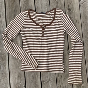 Superfin topp Brandy Melville - Jättefin långärmad randig topp i brunt och vitt från Brandy Melville. Knappt använd, så i superskick. Onesize (motsvarande xs-s). 100% bomull och jättemjuk. 