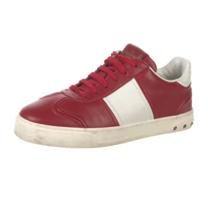 Valentino flycrew Garavani röda och vita sneakers - Snygga sneakers från Valentino Garavani i rött och vitt skinn med klassisk snörning och rund tå. Skorna har en vit sula med små nitar på sidan och en kontrasterande vit panel på sidorna. Perfekta för dig som vill sticka ut med stil.