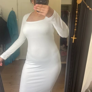 Lång klänning - En vit lång klänning med en fin ringning!! Aldrig använd helt ny!!! Minns ej vilken hemsida det var jag beställde den ifrån!!