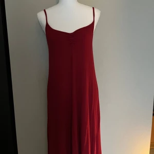 Vinröd långklänning med smala axelband - Vinröd långklänning med smala axelband och lätt rynkdetalj vid bysten. 
