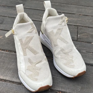 Vita sneakers från Michael Kors - Äkta Michael Kors skor. Använda flera gånger men i hyfsat bra skick. Storlek 37. 
