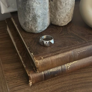 Peak rivet ring - Säljer en cool Edblad ring med ett markerat geometriskt mönster/ större nitar. Ringen är som ny. Storlek 17,5 mm.