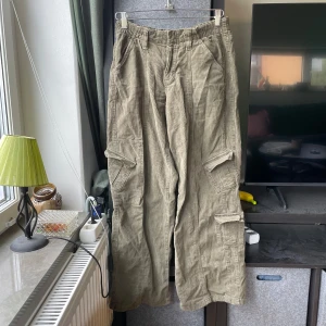 cargobyxor BDG Urban Outfitters - Säljer ett par olivgröna cargobyxor i manchester från BDG Urban Outfitters. Byxorna har flera stora fickor på sidorna och en avslappnad, rak passform. Perfekta för en cool och avslappnad stil.