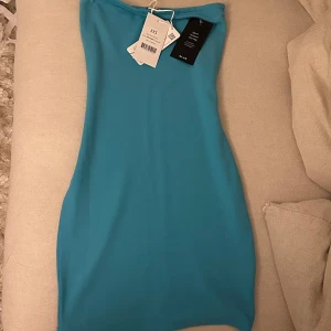 Blå tubklänning nakd - Superfin blå tubklänning från nakd, aldrig använd prislapparna på🦋🩵 slutsåld på hemsidan, sitter som tubklänningen på den andra bilden, passar mig som har storlek XS/S