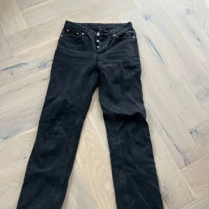 Svarta jeans från Weekday - Ett par mid-waist jeans från Weekday med normal passform, raka ben, och lång längd. I väldigt bra skick. Modell: pin. Storlek 27/30. Ny pris 600 kr.