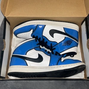 Air Jordan 1 Mid SE ’Signal Blue’ - Säljer ett par Nike Air Jordans i blått, vitt och svart. Skorna har högt skaft, svart snörning och klassisk Air Jordan-logga på sidan. Perfekta för dig som gillar streetwear och vill sticka ut med färg. De är i jättefint skick och jag köpte de nya för 3300kr så säljer de nu för halva priset! Men priset kan såklart diskuteras 🥰💗