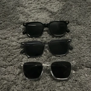 Solglasögon  - Säljer tre par stilrena solglasögon med fyrkantig form. Ett par svarta ett mörkgrått och ett genomskinligt par. Alla har mörka linser och passar perfekt för en trendig look. Dessa glasögon är sjukt stiliga och riktigt bekväma.