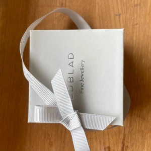 Silverfärgat medaljonghalsband från Edblad - Säljer ett stilrent och elegant silverfärgat medaljonghalsband från Edblad. Medaljongen är rund och öppningsbar, perfekt för att lägga i ett litet foto eller minne. Kommer i original ask med vit rosett. Ny köpt och oanvänt men finns inget kvitto!🥰 Hör av er om ni har några frågor! Ny pris 500kr