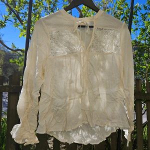 Blus OBS skrynklig  - Vit blus med volang i ärmarna. OBS levereras nytvättad och struken. 