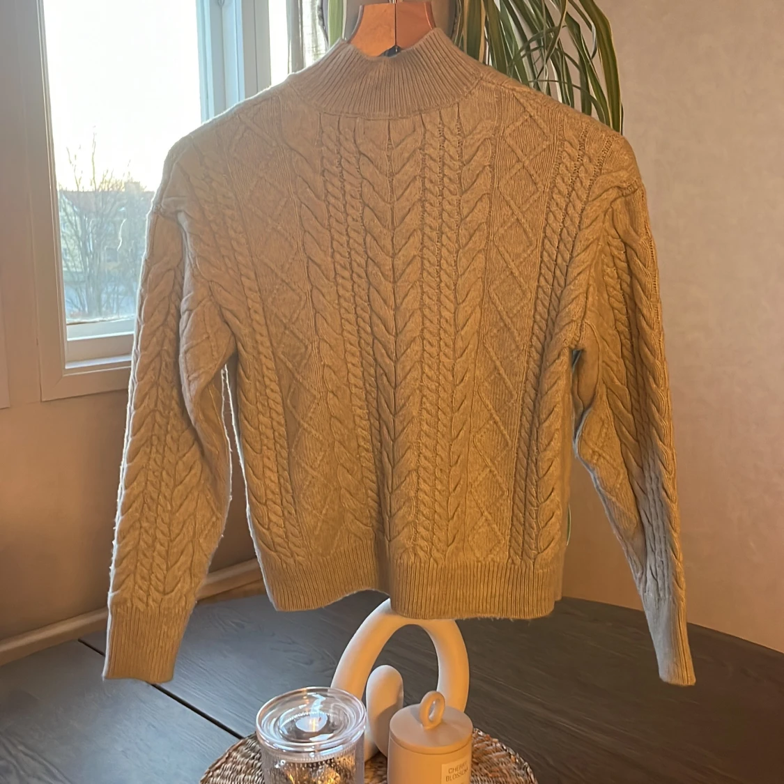 Grå stickad tröja med kabelmönster