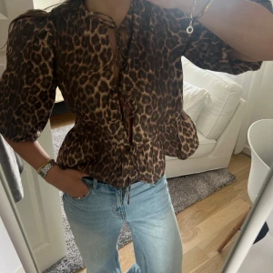 Leopardmönstrad blus med puffärm - Säljer en snygg leopardmönstrad blus med puffiga ärmar och knytning framtill. Blusen har en markerad midja och är perfekt för dig som vill sticka ut. Passar till både jeans och kjol. Eftertraktad!