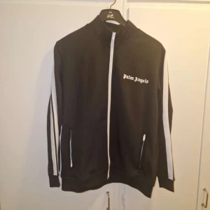 Svart hoodie zipper från palm angels  - Svart hoodie med zip från Palm Angels. Perfekt för en sportig och trendig stil.