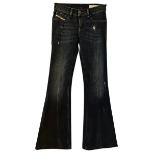 Mörkblå bootcut jeans från Diesel - Snygga mörkblå jeans från Diesel med bootcut passform och klassiska fem fickor. Jeansen har slitna detaljer och kontrastsömmar, samt en liten logotyp på fickan fram. Perfekta för dig som gillar en retroinspirerad look.