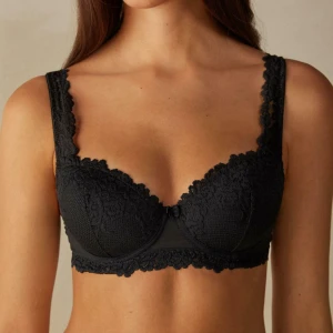 Intimissimi svart spets-bh  - Säljer en svart bh från intimissimi med fina spetsdetaljer längs axelbanden och nederkanten. Bh:n har justerbara axelband och en klassisk hysk- och hakknäppning bak. Perfekt för dig som vill ha något både snyggt och bekvämt. Lappen är avklippt men ska bara storlek 80D. 