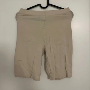 Beige cykelbyxor - Säljer ett par beige cykelbyxor i stretchigt material. De har en hög midja och är knälånga, perfekta för en avslappnad och sportig stil. Passar bra till oversized t-shirt eller hoodie.