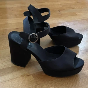 Svarta klackskor med platå - Endast använda en gång och därför i mycket bra skick!  Klacken är 10 cm Storlek 39
