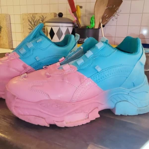 Chunky sneakers i blått och rosa - Färgglada chunky sneakers med kraftig sula i tvådelad design: övre delen är blå och nedre delen är rosa. Skorna har snörning och en sportig look, perfekta för dig som vill sticka ut.