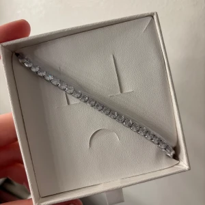 Armband - Ett jätte fint silverarmband med stenar runt hela vägen. Säljer för jag fick två likadana, den är helt oanvänd och ligger i original förpackningen samt plast runt armbandet.   Original pris 600kr