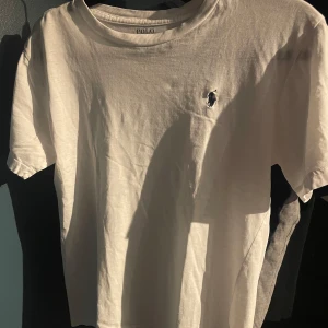 Vit t-shirt från Polo Ralph Lauren - Vit t-shirt från Polo Ralph Lauren med broderade loggan på bröstet. Litet hål under armen men inget som syns.