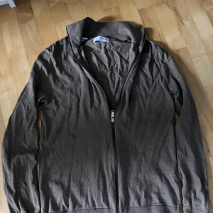 Brun kofta med dragkedja från Selected Homme - Säljer en brun kofta från Selected Homme med dragkedja framtill. Enkel och stilren design.