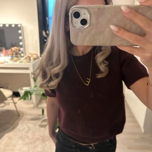 Vinröd stickad tröja från Gina Tricot - Mysig vinröd stickad tröja från Gina Tricot med rund halsringning och korta ärmar. Perfekt för lager-på-lager och enkel att matcha med jeans eller kjol.