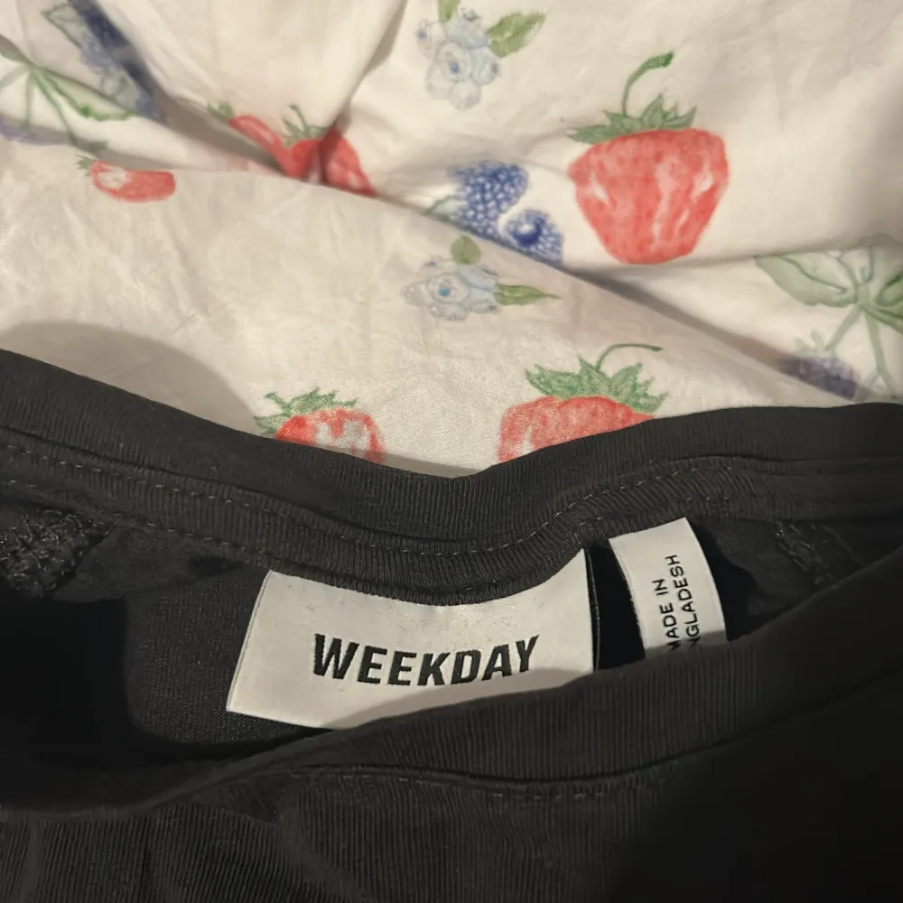 Säljer en svart topp från Weekday med korta volangärmar och rund halsringning. Toppens material känns mjukt och stretchigt, perfekt för en stilren look. Passar bra till både jeans och kjol 🫶🏼🫶🏼. Yläosat.