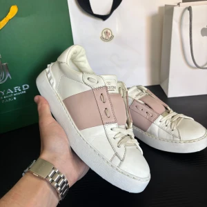 Valentino Garavani Open sneakers vit/rosa - Valentino Garavani Sneakers – Pink Stripe 	•	Äkta Valentino Garavani sneakers 	•	Rosa metallic stripe – stilren och lyxig design 	•	Mycket bra skick, inga defekter 	•	Storlek 36 – passar även 36–37 	•	Condition – 9/10  🚚 FAST SHIPPING ON ALL ORDERS 🧼 📦 No returns 📦 ✅ All products are 100% authentic