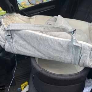 Grå babyväska från Najell - Säljer en mjuk och praktisk babyväska från Najell i ljusgrått tyg med handtag. Väskan har en stilren design och är tillverkad i bomull och polyester. Perfekt för att bära med sig det viktigaste till bebisen. Enkel att ta med i bilen eller vagnen. Finns en fläck som är cola så går bort. Volym 2