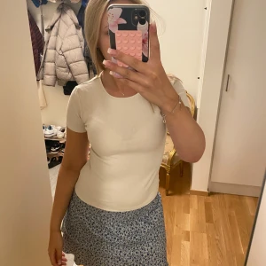 Vit ribbad kortärmad topp - Säljer en enkel och fräsch vit ribbad topp med korta ärmar. Modellen är figurnära och har rund halsringning. Perfekt att matcha med kjol eller jeans för en clean look. Supermjuk och stretchig, passar dig som gillar basic men snyggt.