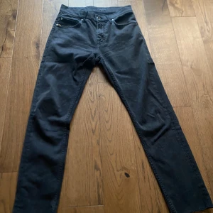 Svarta tiger of Sweden jeans  - Svarta  jeans med klassisk femficksdesign och smal passform. Jeansen har bälteshällor och knappstängning framtill. Perfekta för dig som gillar en stilren och enkel look.