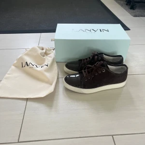 Lanvin -  Bruna sneakers från Lanvin med ovandel i mocka och lackad tå. . Kommer med originalbox och dustbag. Använda fåtal gånger. UK 6