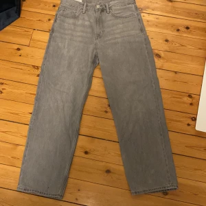 Grå loose fit jeans från H&M - Säljer ett par gråa loose fit jeans från H&M i storlek 30/32. De har raka ben och en avslappnad passform